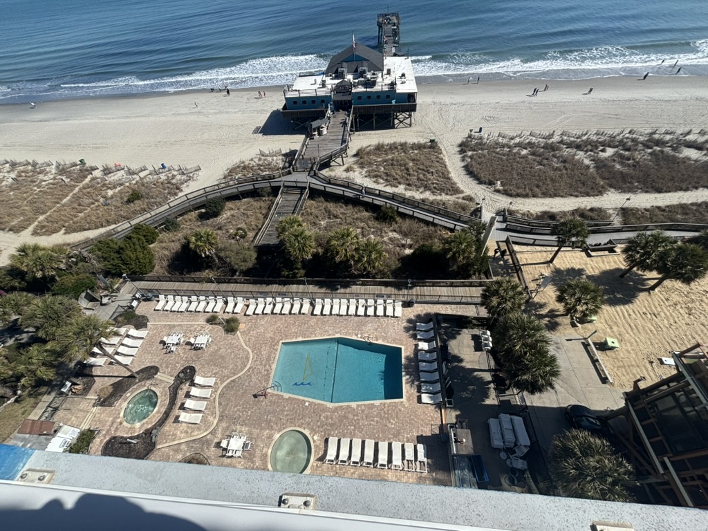 View from The Yachtsman balcony — ocean, pool, and pier